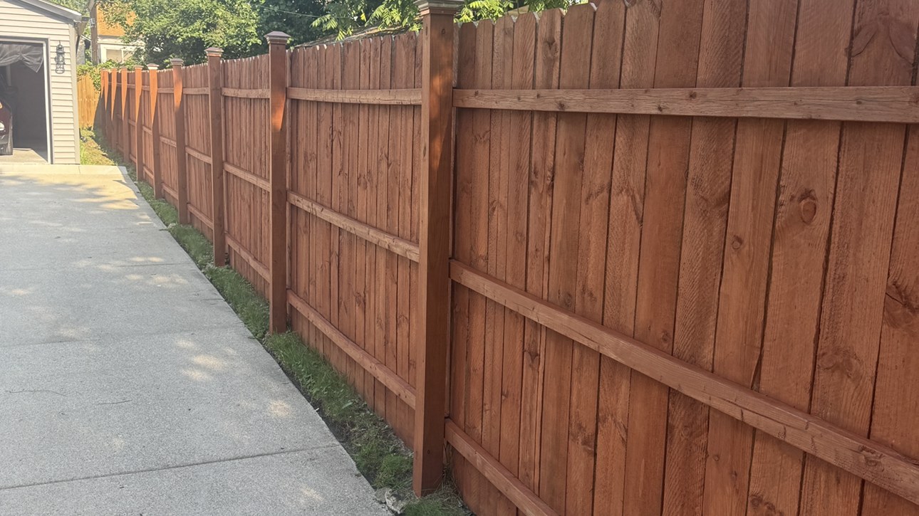 Long fence line stained on a rural Essex County property